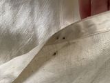 a hand that is holding a piece of fabric with a hole in it