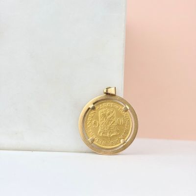 une pièce d'or posée sur un bloc de marbre
