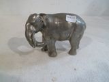 statue d'un éléphant avec une étiquette accrochée à sa défense