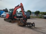 an image of a small excavator in a parking lot