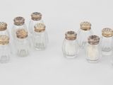six petites bouteilles en verre contenant des salières et des poivrières