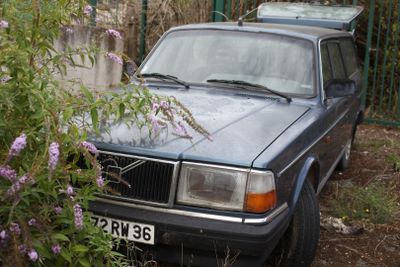 a car that is parked next to a fence
