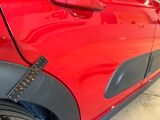 a close up of a red car with a sticker on it