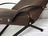 a brown chair that is sitting on a white bed
