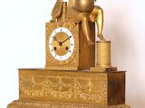 une horloge en or surmontée d'une statue