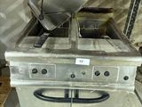 a silver stove with a fryer on top of it in a warehouse