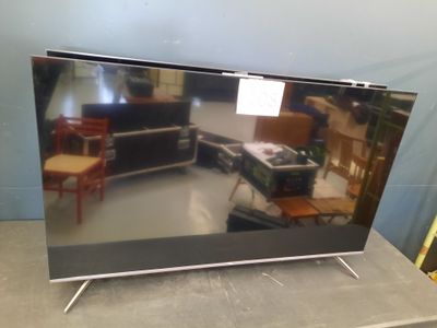 television sitting on top of a table in a room next to a chair