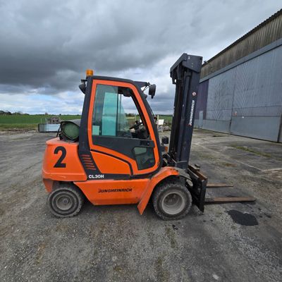 un chariot élévateur orange garé sur un parking