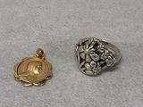 two silver and gold rings sitting on top of a white surface