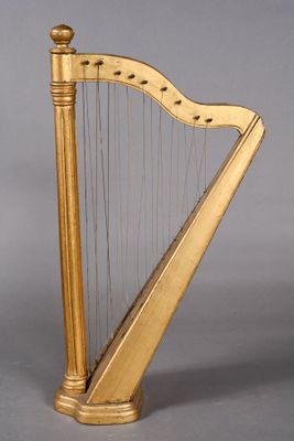 an image of a golden harp sitting on top of a wooden stand