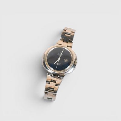une image d'un gros plan d'une montre-bracelet sur une surface blanche