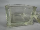 a clear glass container with a lid on a table