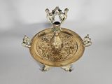 an antique brass plate with two birds on it