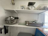 a shelf with a bowl and a pan on it in a kitchen