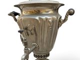 a silver urn that is on a stand on a white background