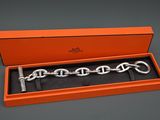 une boîte orange contenant un bracelet à chaîne argentée