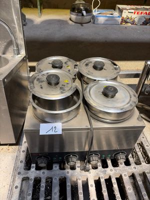 une machine sur laquelle sont posés quatre récipients métalliques