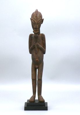 l'image d'une statue en bois représentant un homme avec un chapeau sur la tête