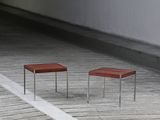 two small tables sitting on a wooden floor in a room