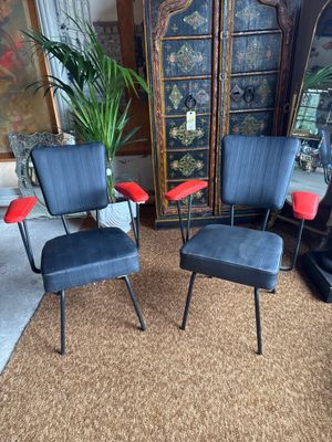 two chairs and a ottoman in a living room with a plant