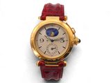 une photo d'une montre-bracelet en or avec un bracelet en cuir rouge