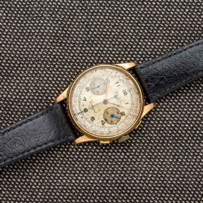 un gros plan d'une montre posée sur un tissu noir
