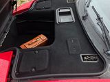 a trunk of a red car with a suitcase in it
