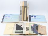 several books are stacked on top of each other on a white surface