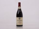 la bouteille de vin rouge est posée sur une surface blanche