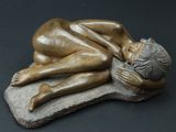 statue représentant une femme allongée sur un rocher, la tête posée sur ses mains