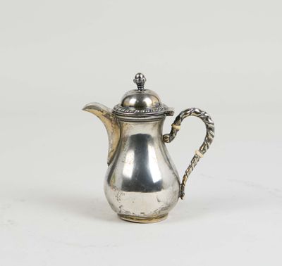a silver tea pot with a handle on a white surface