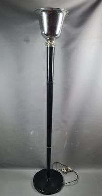 a black floor lamp with a glass shade on top of it