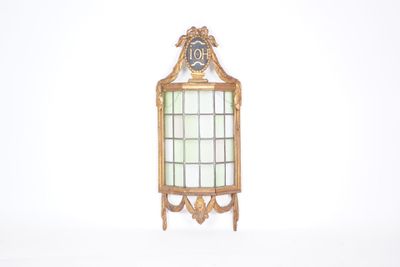 un petit miroir avec un cadre doré et une horloge dessus