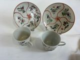 two cups and a saucer sitting on a table