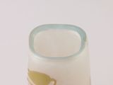 a small glass vase with a yellow and white design on it
