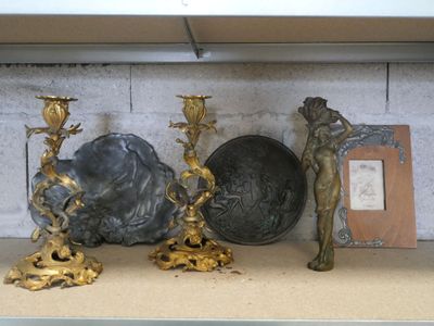 une étagère sur laquelle sont disposés de nombreux objets anciens