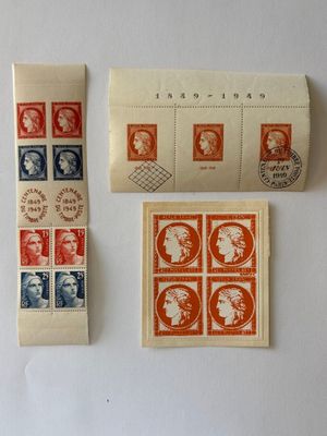 trois timbres et un rouleau de papier posés sur une surface blanche