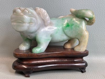 a small statue of a dog on a wooden stand