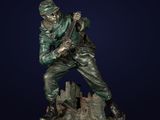 a bronze statue of a soldier on a rock with a rifle