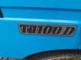 a close up of a blue truck with a wood sign on it