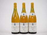 trois bouteilles de vin sont posées côte à côte sur une surface blanche