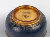 un vase bleu et doré sur lequel figure une inscription