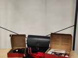 deux boîtes posées sur une table, sur laquelle se trouvent un sac à main et d'autres objets