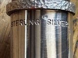a close up of a silver cup on a wooden table