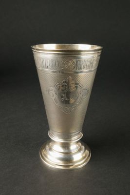 une coupe ancienne en argent ornée d'un motif sur le côté