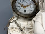 a statue of a woman holding a clock and a key
