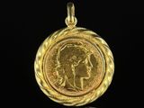 a gold coin with a woman ' s face in the center