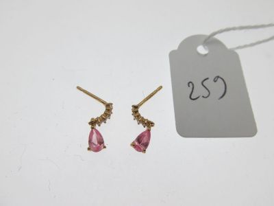 une paire de boucles d'oreilles roses et dorées avec une étiquette de prix
