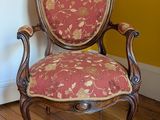 une chaise rouge et dorée dans une pièce aux murs jaunes