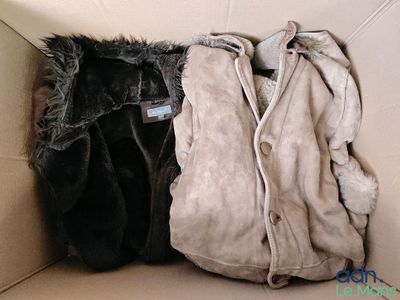 deux vestes dans une boîte en carton : l'une est noire et l'autre est marron